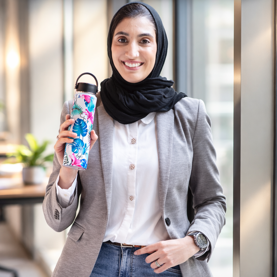 Owner holding a colorful water bottle in an office setting with text about starting a brand and needing help with Instagram.